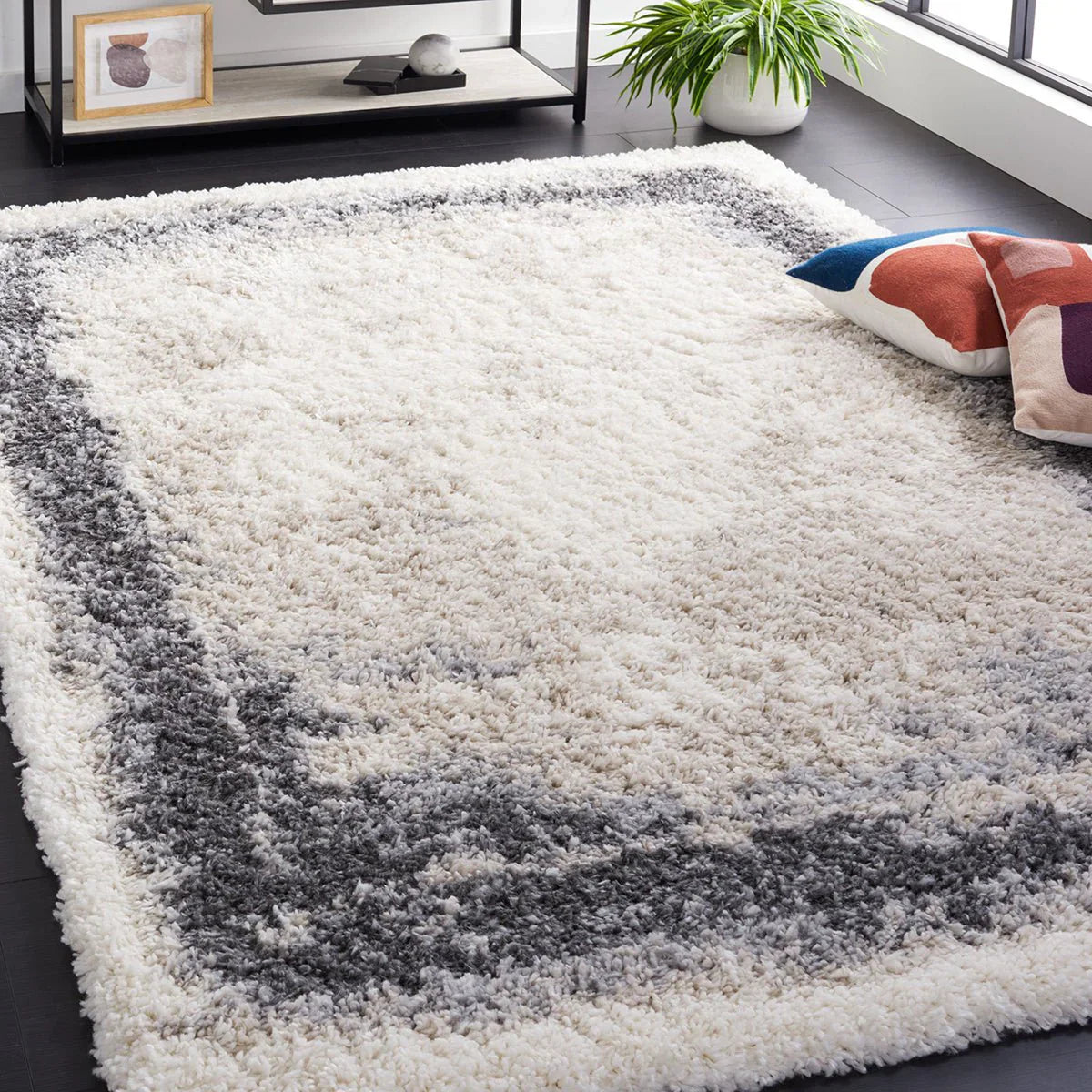 Cozy living space featuring a plush shaggy rug with grey border pillows and indoor plant