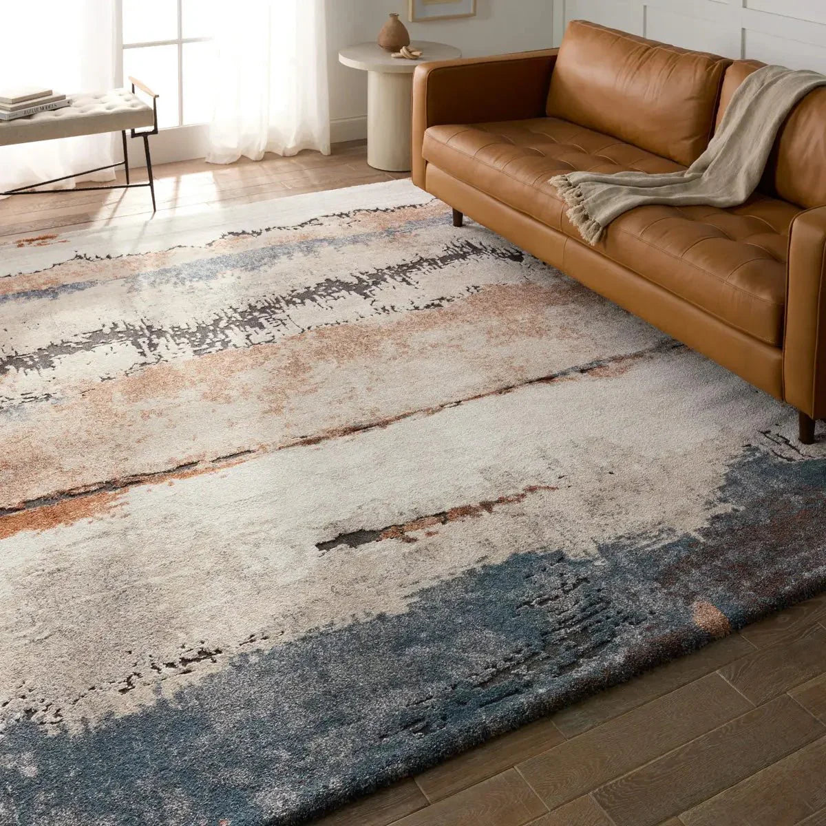 Modern living room with abstract extra large rug under leather sofa and natural sunlight