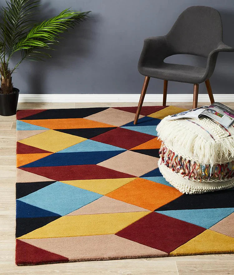 Bold geometric modern rug in colorful living room with grey chair ottoman and indoor plant